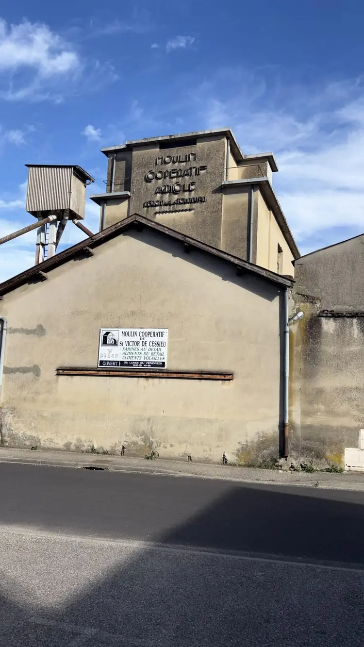 Façade du moulin coopératif de Saint-Victor-de-Cessieu : la tour porte l'inscription « Moulin coopératif agricole »
